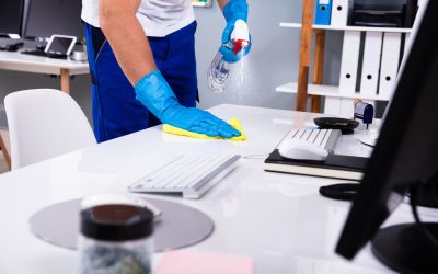 Janitor cleaning white desk in modern office